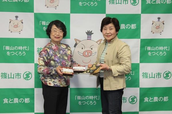 代表の森本 淑子さん、平田 道代さんが「とふめし」を持っている写真